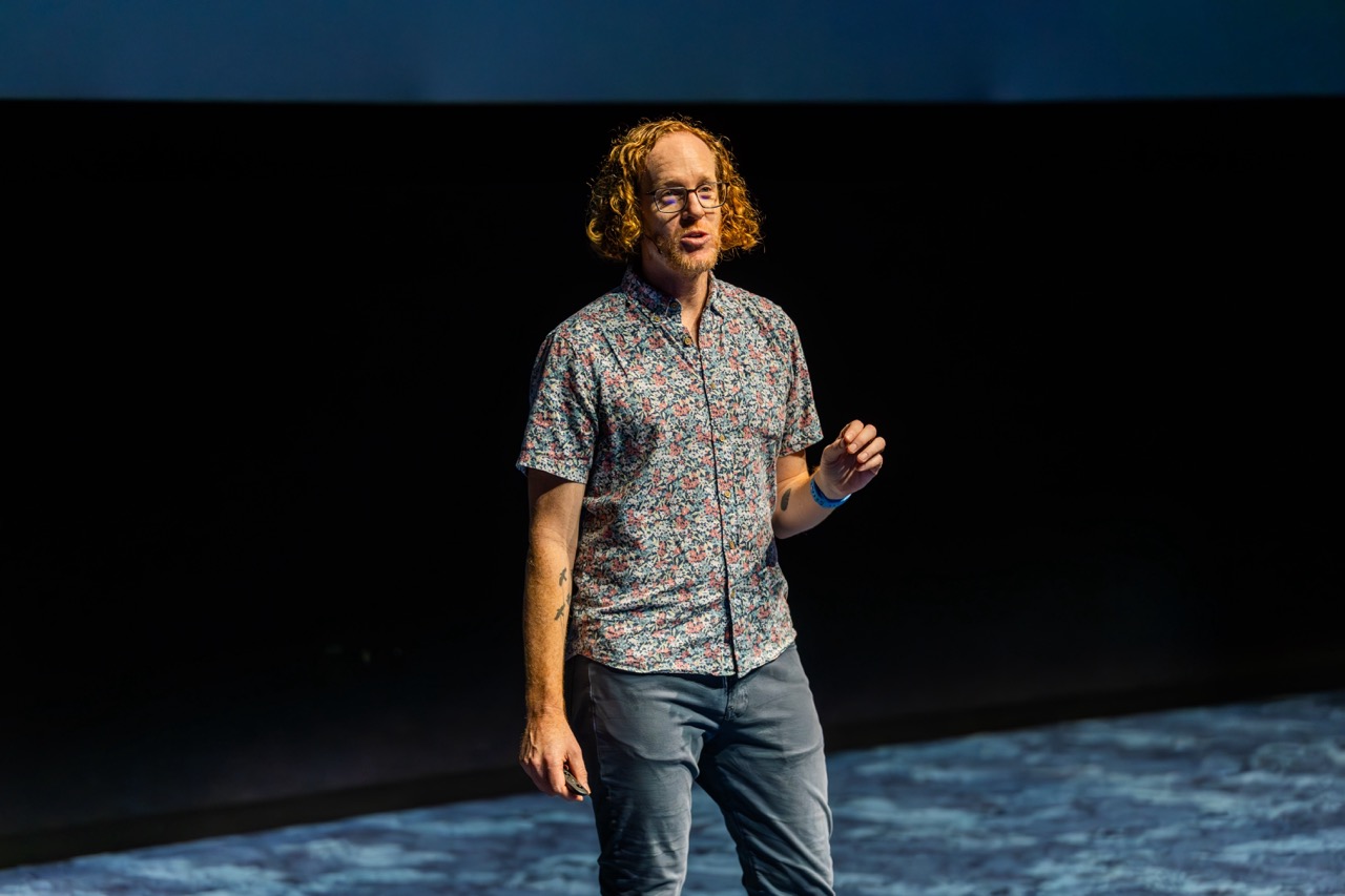 Robby Russell speaking on stage at SquiggleConf 2024 in Boston